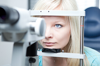 Woman having an eye exam with a slit lamp